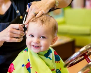 Tuinposter Happy toddler child getting his first haircut © Robert Hainer