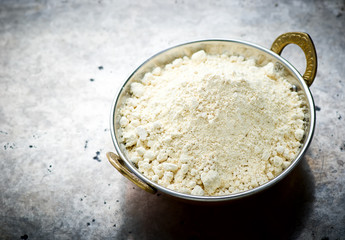 Flour from chick-pea in the Indian copper bowl
