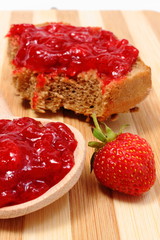 Fresh fruits and strawberry jam on wooden cutting board