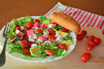 Mixed vegetable salad with crab sticks and avocado