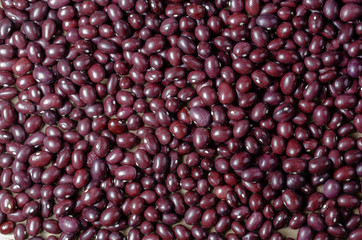 Red edible bean over wood.