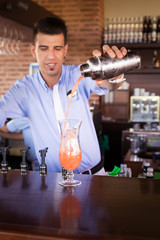 Bartender preparing Sex on the beach cocktail in an outdoor bar