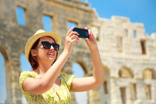 Woman Taking Photo of Arena with Smartphone