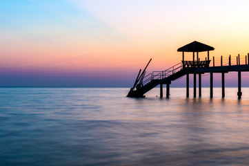 Colorful sunset at tropical beach with jetty