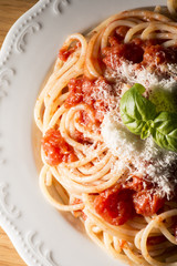 dish with spaghetti and tomato sauce on the wooden table