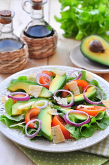Fresh salad with tomatoes, lettuce,  avocado and parmesan cheese
