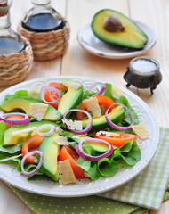 Fresh salad with tomatoes, lettuce,  avocado and parmesan cheese
