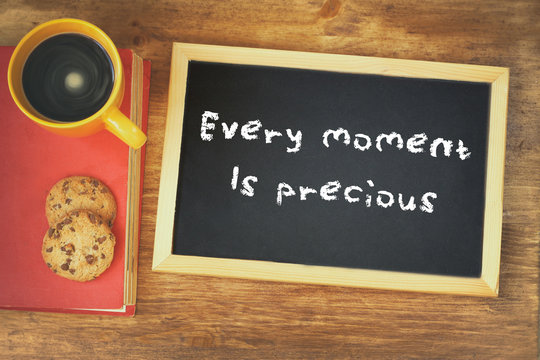 top view of blackboard with the phrase every moment is precious 