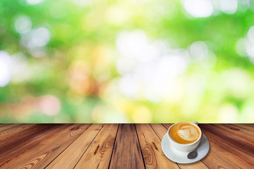 Coffee on table with bokeh background in garden