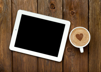 Tablet and coffee on a wooden table