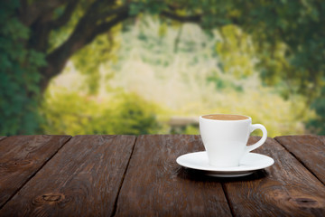 Coffee on wooden table with beautiful forrest background
