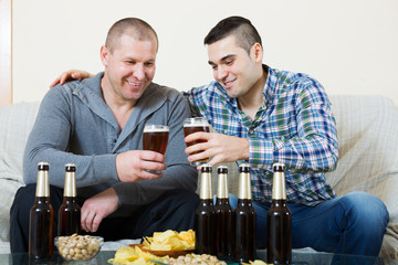 Two man with beer sit and talk