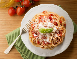 dish with spaghetti and tomato sauce on the wooden table