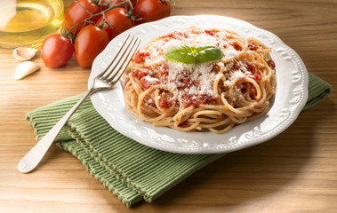 dish with spaghetti and tomato sauce on the wooden table