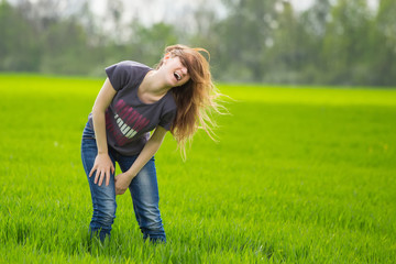 happy woman standing at the green field