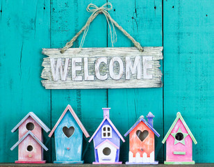 Welcome sign hanging over colorful birdhouses