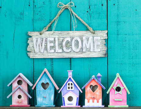 Welcome sign hanging over colorful birdhouses