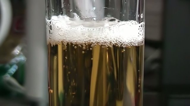 Pouring light beer into glass.