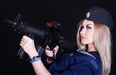 Woman in the marine uniform with an assault rifle