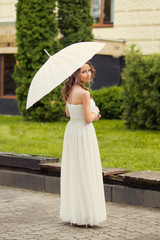 Beautiful happy bride in white dress with decorative umbrella ag