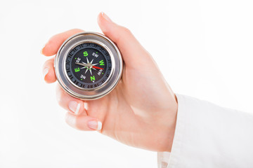 Woman holding small compass. Isolated in a white background. © kozirsky