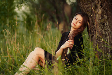 Candid skipping carefree adorable woman in field near tree at su