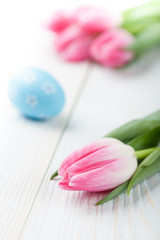 Pink tulips and Easter egg on the white table
