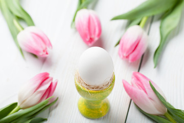 White egg on the stand with tulips