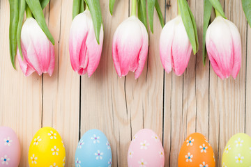 Pink tulips and colorful Easter eggs in rows