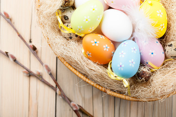 Colorful Easter eggs in the basket with willow branch