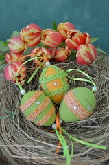 Ostereier im Nest mit Tulpen mit Textfreiraum