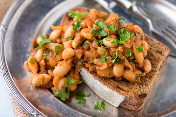 Stewed white beans in tomato sauce on toasted bread