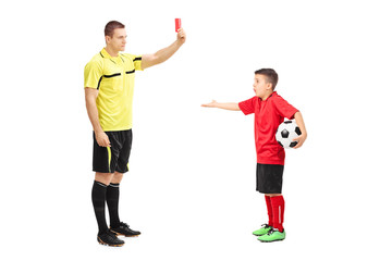 Football referee showing red card to a boy