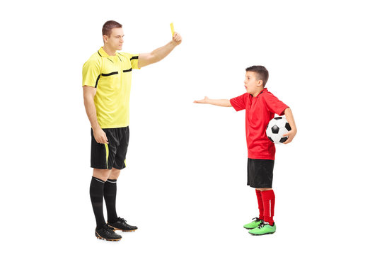 Football referee showing yellow card to a boy
