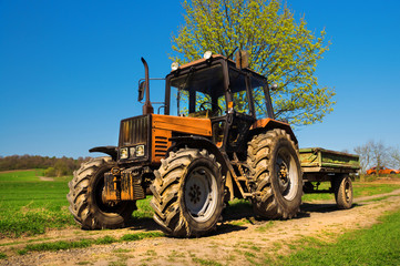 Naklejka premium Red rusty tractor on a field