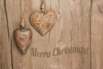 Wooden heart decorations on vintage wood,text "Merry Christmas"