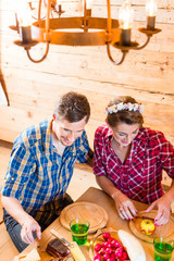 Mann und Frau essen Brotzeit auf Berghütte