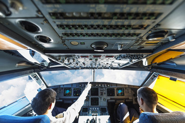 Pilots in the plane cockpit and cloudy sky