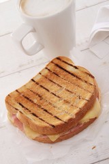 toasted cheese and ham sandwich with coffee