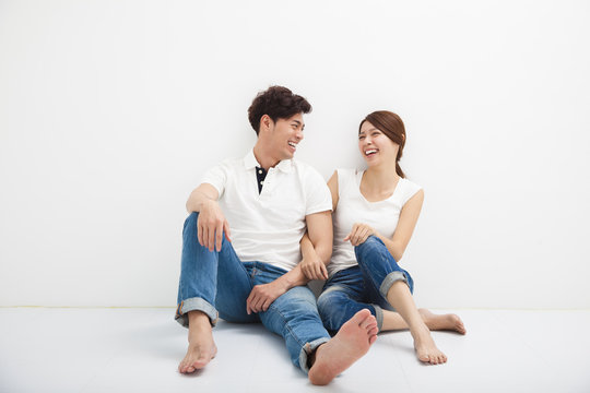 Happy Young Asian Couple Sitting On Floor