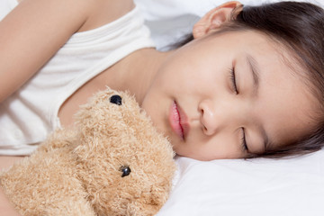Obraz na płótnie Canvas Adorable little Asian girl sleep on her bed with bear doll