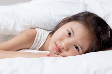 Lovely Asian child laying down on the bed