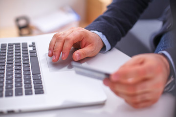 Businessman using his credit card for an online transaction