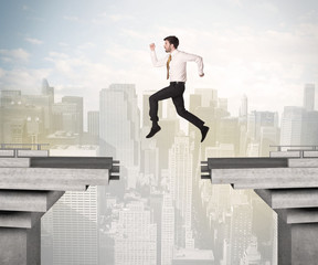 Energetic business man jumping over a bridge with gap