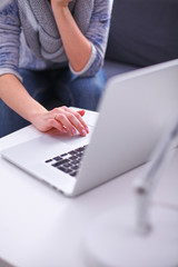 Woman working with a laptop sitting at the desk