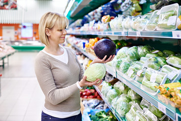 Woman buys a red and white cabbage in store