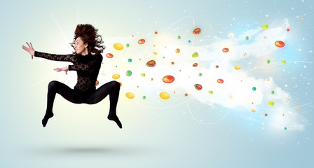 Fototapeta na wymiar Beautiful woman jumping with colorful gems and crystals on the b