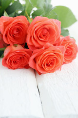 orange roses on a wooden board