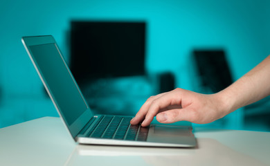 Businessman pressing modern laptop computer on colorful backgrou
