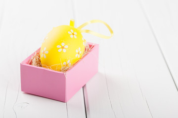 Yellow egg in the pink gift box